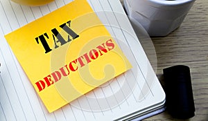 Writing text showing Tax Deductions. Business concept for Finance Incoming Tax Money Deduction written sticky note empty paper, Wo