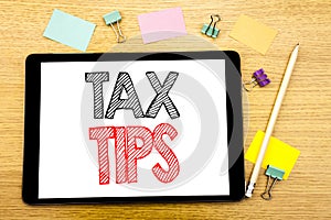 Writing text showing Tax Tips. Business concept for Tip Forn Taxes Written on tablet laptop, wooden background with sticky note an