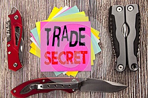 Writing text showing Trade Secret. Business concept for Data Protection Written on sticky note wooden background with pocket knife