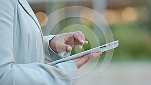 Writing, typing and texting closeup of a businessperson holding a tablet outside connected and networking on the go