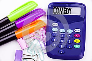 Writing word Comedy text in the office with surroundings such as marker, pen writing on calculator. Business concept for Stand Up
