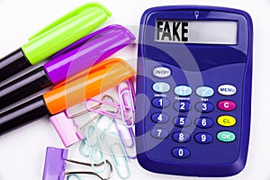 Writing word Fake News text in the office with surroundings such as marker, pen writing on calculator. Business concept for Fake N