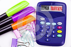 Writing word Human Trafficking text in the office with surroundings such as marker, pen writing on calculator Business concept for