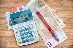 2021 written on a calculator and euros banknotes, new year money,finances and budget in Europe concept photo