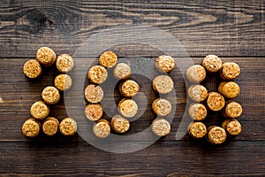 New Year celebration concept. 2018 written with corks of wine bottles on dark wooden background top view