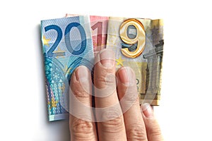 2019 written with euros bank notes in a hand isolated on white