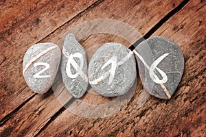 2016 written on a line of stones on a wood