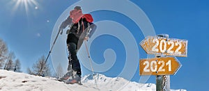 2022 written on a postsign with a man in touring ski