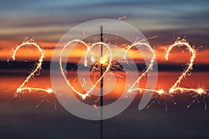 2022 written with Sparkle firework on sunset background, happy new year 2022 concept