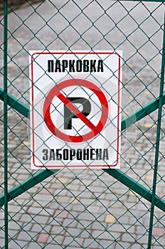 It is written in Ukrainian: `parking is prohibited.` The road sign is attached to the gate.