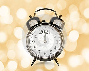 2021 written on a vintage alarm clock, bokeh lights background, happy new year eve party time and midnight countdown