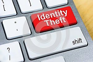 Written word Identity Theft on red keyboard button. Online Prote