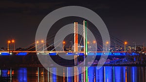 Wroclaw, Millennium Bridge over the Odra River illuminated at night, colorful lighting will be reflected in the water