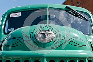 WROCLAW, POLAND - August 11, 2019: USA cars show: Old Dodge car. Green Vintage renovated hood with logo against windshield. Close-