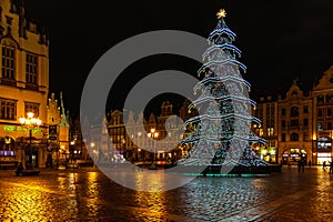 Wroclaw market square at night with some of walking people, glowing lanterns and beautifully and