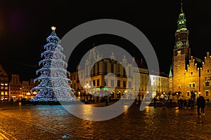 Wroclaw market square at night with some of walking people, glowing lanterns and beautifully and