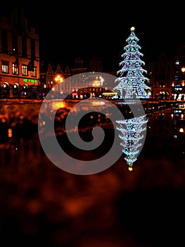 Wroclaw market square at night with some of walking people, glowing lanterns and beautifully and