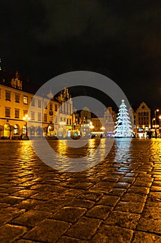 Wroclaw market square at night with some of walking people, glowing lanterns and beautifully and