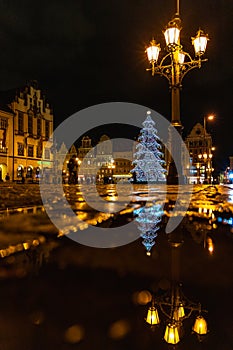 Wroclaw market square at night with some of walking people, glowing lanterns and beautifully and