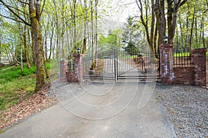 Wrought iron driveway gates with red brick columns.