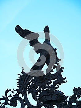 Wrought iron eagle on a gateway to a courtyard garden