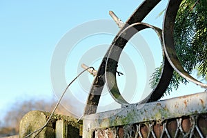 Wrought iron garden gate showing improvised spikes to help prevent crime.