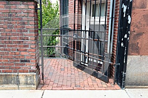 Wrought iron gate door over brick sidewalk passage between buildings