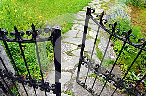 Wrought iron gate, garden stone path