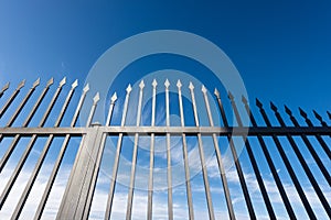 Wrought Iron Gate with Sharp Points on Blue Sky with Clouds