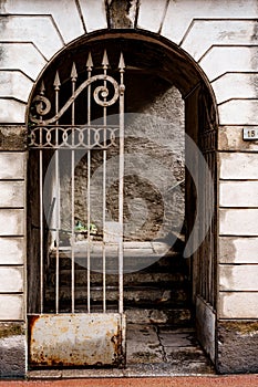 Wrought-iron gate with sharp prongs in the arched entrance to the building