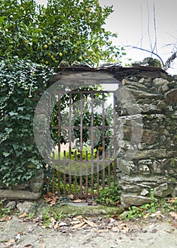 Wrought iron gate in slate wall with wooden roof in Robledillo de Gata