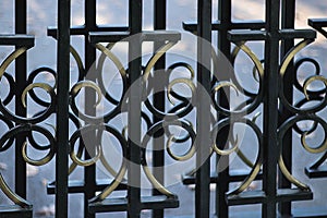 Wrought iron metal gate with geometric pattern. Wrought iron tracery fence fragment