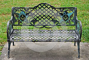 A wrought iron park bench front view