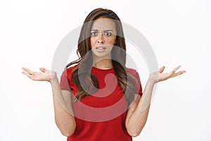 Wtf going on explain. Intense frustrated and shocked young brunette woman, raising hands up make shoulder shrug photo