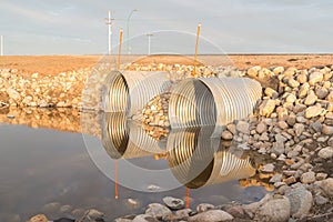 Wtwo steel culverts reflecting in water photo