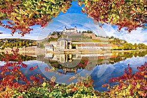 Wurzburg. Main river waterfront and scenic Wurzburg castle and vineyards reflection view through autumn leaves