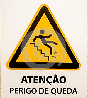 "atenÃ§Ã£o, perigo de queda" sign.  Triangular shape with person falling from steps on yellow background. photo