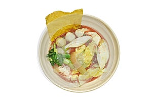 boiled Chinese pork dumpling with fish ball and morning glory vegetable in red soup on bowl