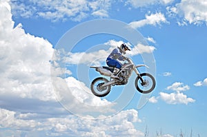 X games driver standing on the MX motorcycle is flying over the photo