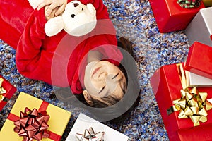 X-mas and holiday concept. Happy childen girl with gift box. Girl in christmas cap hands present wrapped with gold paper and red