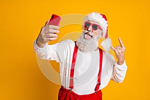 X-mas party hard. Portrait of funny crazy santa claus in red hat take selfie smart phone christmas blogger show horns