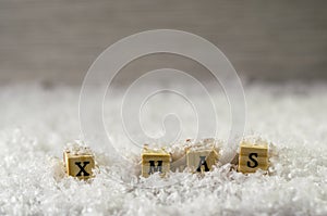 X mas word made of letters on wooden cubes on a snow background 3