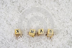 X mas word made of letters on wooden cubes on a snow background 2