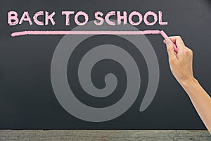 & x22;Back to school& x22; written by pink chalk on the black school chalk