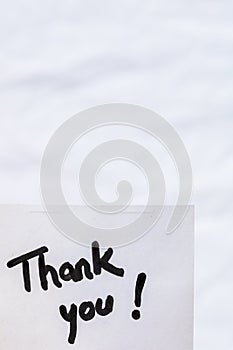 "Thank you" handwriting text on the white paper background with copy space