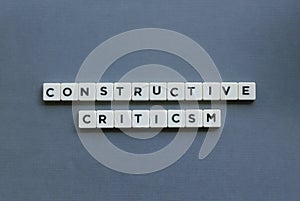 ' Constructive Criticism ' word made of square letter word on grey background