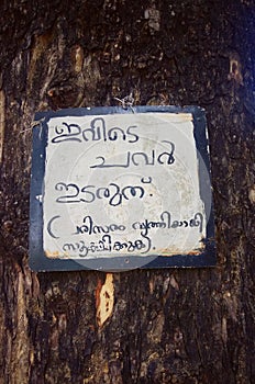 'Do not throw waste here' sign board handwritten in Malayalam Language
