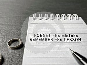 'Forget the mistake remember the lesson' text in background. Inspirational and motivational quote concept. Stock photo.