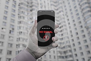 'No Signal' notification on a cell phone screen. No cellular signal. The smartphone in hand against the background of a