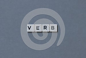 ' Verb ' word made of square letter word on grey background